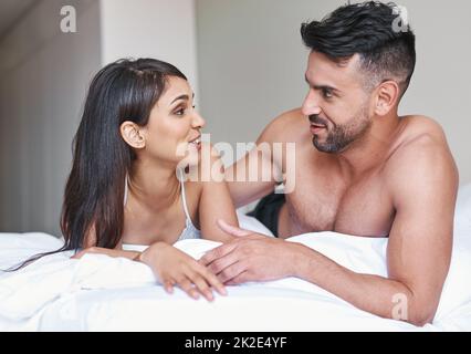 Today we using conversation to wake up. Cropped shot of an affectionate young married couple in bed at home. Stock Photo
