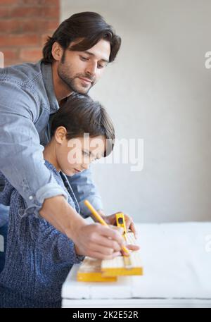 Learning everything dad has to teach. A father and son doing woodwork together. Stock Photo
