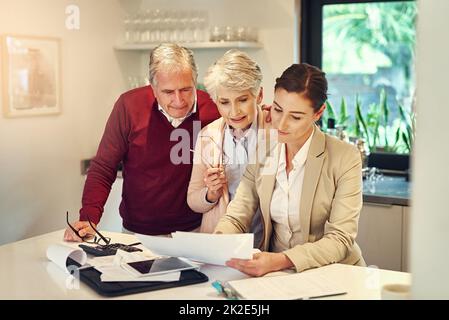 Maintaining the same standard of living because we saved. Shot of a senior couple getting advice from their financial consultant. Stock Photo