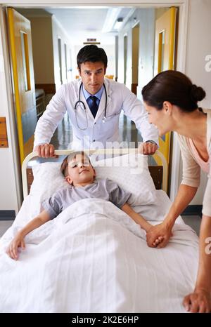 As long as moms here Ill be fine. Shot of a doctor wheeling a young patient down a corridor. Stock Photo