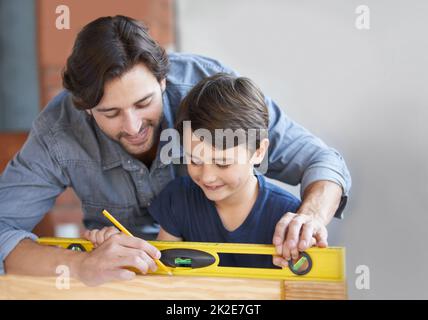 Bonding over DIY. A father and son doing woodwork together. Stock Photo