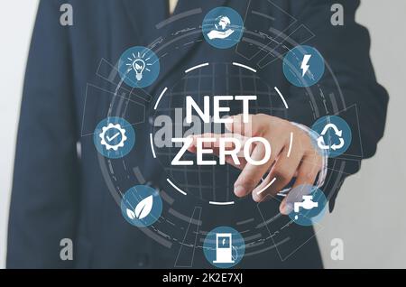 Businessman touching net zero save the eco world and reduce pollution virtual screen. virtual screen Business Technology Concept. Stock Photo