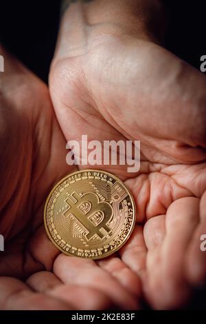 Gold bitcoin cryptocurrency in a hands Stock Photo