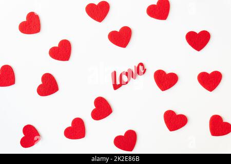 The background which consists of red hearts, the inscription love in the middle of the hearts. Love concept, greeting card for valentine's day. Stock Photo