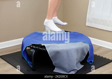 Male Legs Jumped Up in the Air Over a Round Rebounder Close-up Stock Photo