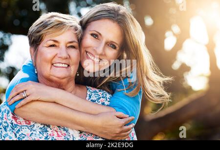 My mom gave me a life filled with love. Portrait of a happy mature woman hugging her mother outdoors. Stock Photo