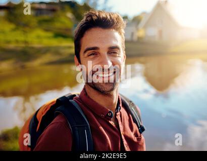 I love being out here. Cropped portrait of a handsome young man spending the day at a lake. Stock Photo