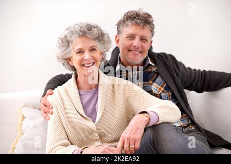 Spending their golden years together. Portrait of a loving senior couple sitting together on a sofa. Stock Photo