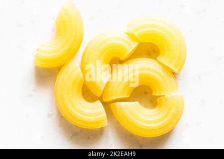 several uncooked chifferini rigati pasta pieces Stock Photo