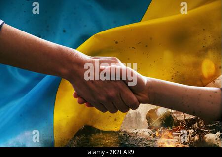 Sunny Ukraine country flag with helping hand as support Stock Photo