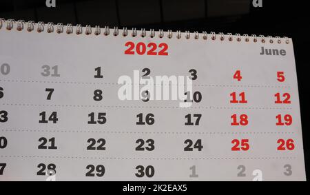 Close-up of a page of a paper calendar with a spiral for the month of June for 2022 on a black background Stock Photo