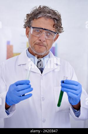 A passion for chemistry. A cropped portrait of a mature scientist holding two test tubes in his lab. Stock Photo