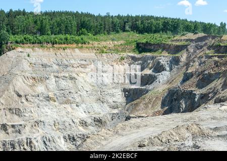 The production of graphite. Industrial background. Deep quarry for the extraction of minerals. Stock Photo