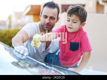 Like father, like son. Cropped shot of a handsome father and his son washing a car together. Stock Photo