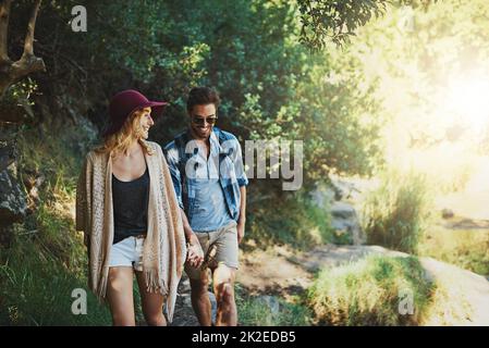 Meanderings through Mother Nature. Shot of a happy young couple exploring nature together. Stock Photo