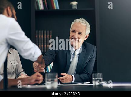 Welcome aboard. Cropped shot of a two businessmen shaking hands during a meeting in the boardroom. Stock Photo