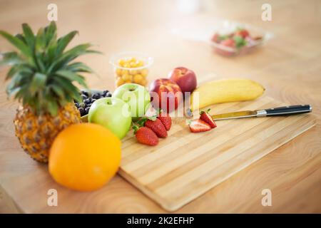 The healthiest of diets. Shot of fresh fruit on a chopping board in the kitchen. Stock Photo