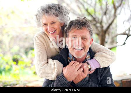 Lovely light-hearted moments together. Portrait of a happily married senior couple bonding outside. Stock Photo