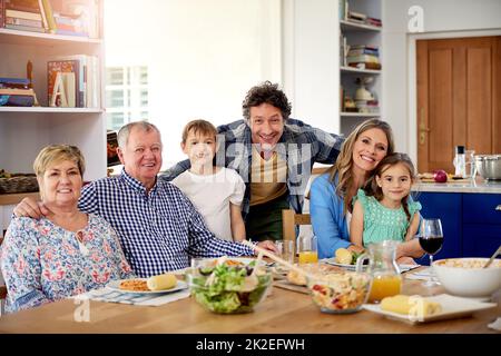 Good times are always on the menu at family gatherings. Portrait of a multi generational family enjoying a meal together at home. Stock Photo