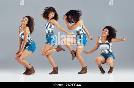 Expressions through dance. Composite image of a carefree young woman posing in studio. Stock Photo
