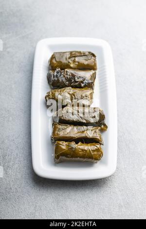 Dolmades. Stuffed vine leaves. Greek appetizer on plate. Stock Photo