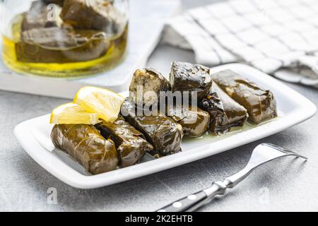 Dolmades. Stuffed vine leaves. Greek appetizer on plate. Stock Photo