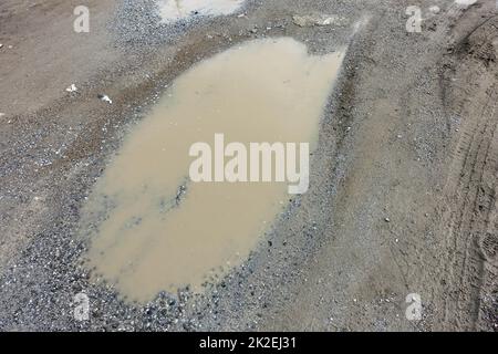 puddles in the city after rain, shapeless and unplanned city streets Stock Photo