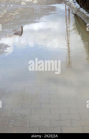 puddles of rain and mud accumulating on city streets Stock Photo