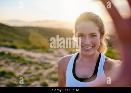 Selfie-worthy scenery. Shot of an attractive young woman taking a selfie while exercising outdoors. Stock Photo