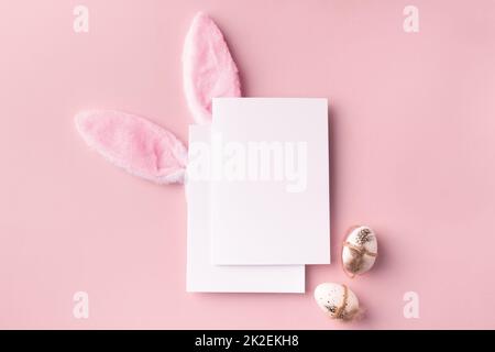 Easter mockup with decorative rabbit ears and eggs, poster on pink background Stock Photo