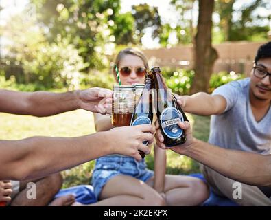 Cheers to life. Cropped shot of a young group of friends toasting while enjoying a few drinks outside in the summer sun. Stock Photo