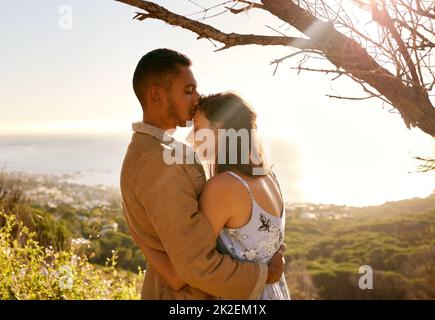 May this moment last forever. Shot of a young couple embracing one another on a date outside in nature. Stock Photo