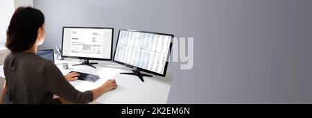 Businesswoman Calculating Invoice On Computer Stock Photo