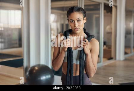 Im a lot tougher than I look. Shot of a young female athlete posing with a rope around her neck. Stock Photo