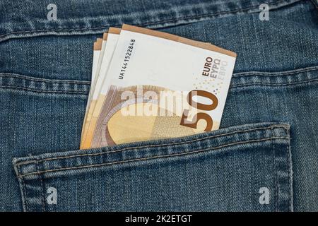 Money in the pocket. Fifty euro notes in the pocket of blue jeans Stock Photo