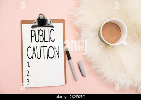 Writing displaying text Public Caution. Conceptual photo formal warning given to the public to express a potential risk Office Supplies Over Desk With Keyboard And Glasses And Coffee Cup For Working Stock Photo