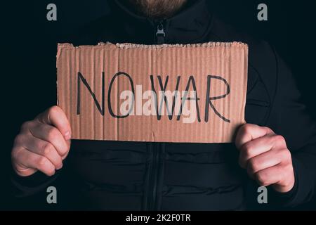 Man with No war banner sitting in the dark Stock Photo