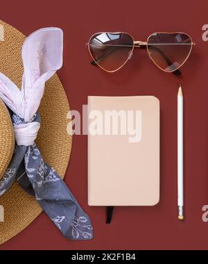 Female summer clothes and accessories flat lay. Hardcover textbook mockup. Stock Photo