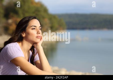 Relaxed woman contemplating lake views on vacation Stock Photo