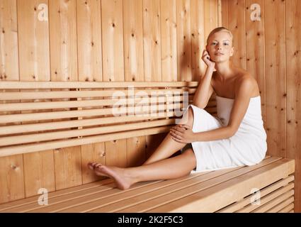 This is her bliss. A gorgeous blond woman relaxing in a sauna. Stock Photo