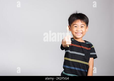 Little cute kid boy 5-6 years old show brush teeth and smile in studio shot isolated Stock Photo