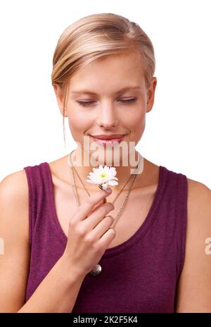 All natural aromatherapy. Studio shot of a young woman smelling a flower isolated on white. Stock Photo