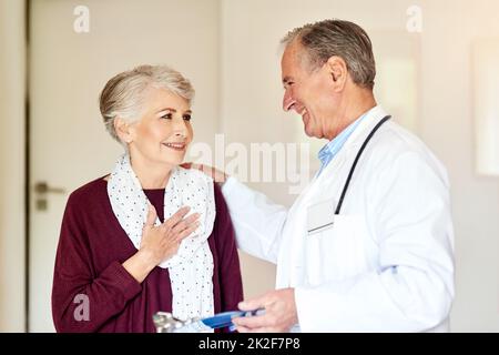 What a relief. Shot of a doctor having a conversation with his patient in the clinic. Stock Photo
