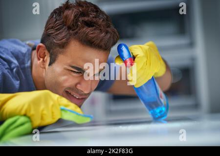 I will get this squeaky clean. Shot of a young man doing household chores. Stock Photo