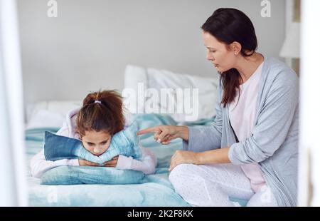 It doesnt matter if youre not sleepy. Shot of a mother disciplining her young daughter at home. Stock Photo