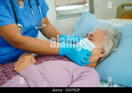 Doctor check Asian elder senior woman patient wearing a mask for protect covid coronavirus. Stock Photo