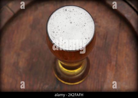 Beer glass on old wooden barrel Stock Photo