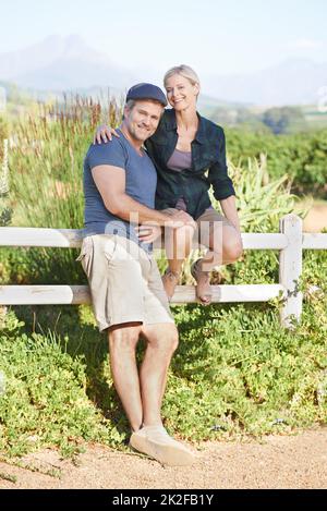 Enjoying a perfect day on the farm. A happy mature couple spending time on a farm together. Stock Photo