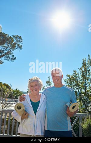 Active and happy in retirement. Portrait of a senior couple standing outside ready to do yoga together. Stock Photo