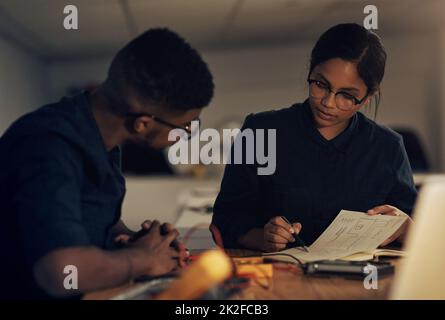 247 expertise for all of your tech needs. Shot of two young technicians having a discussion while repairing computer hardware. Stock Photo